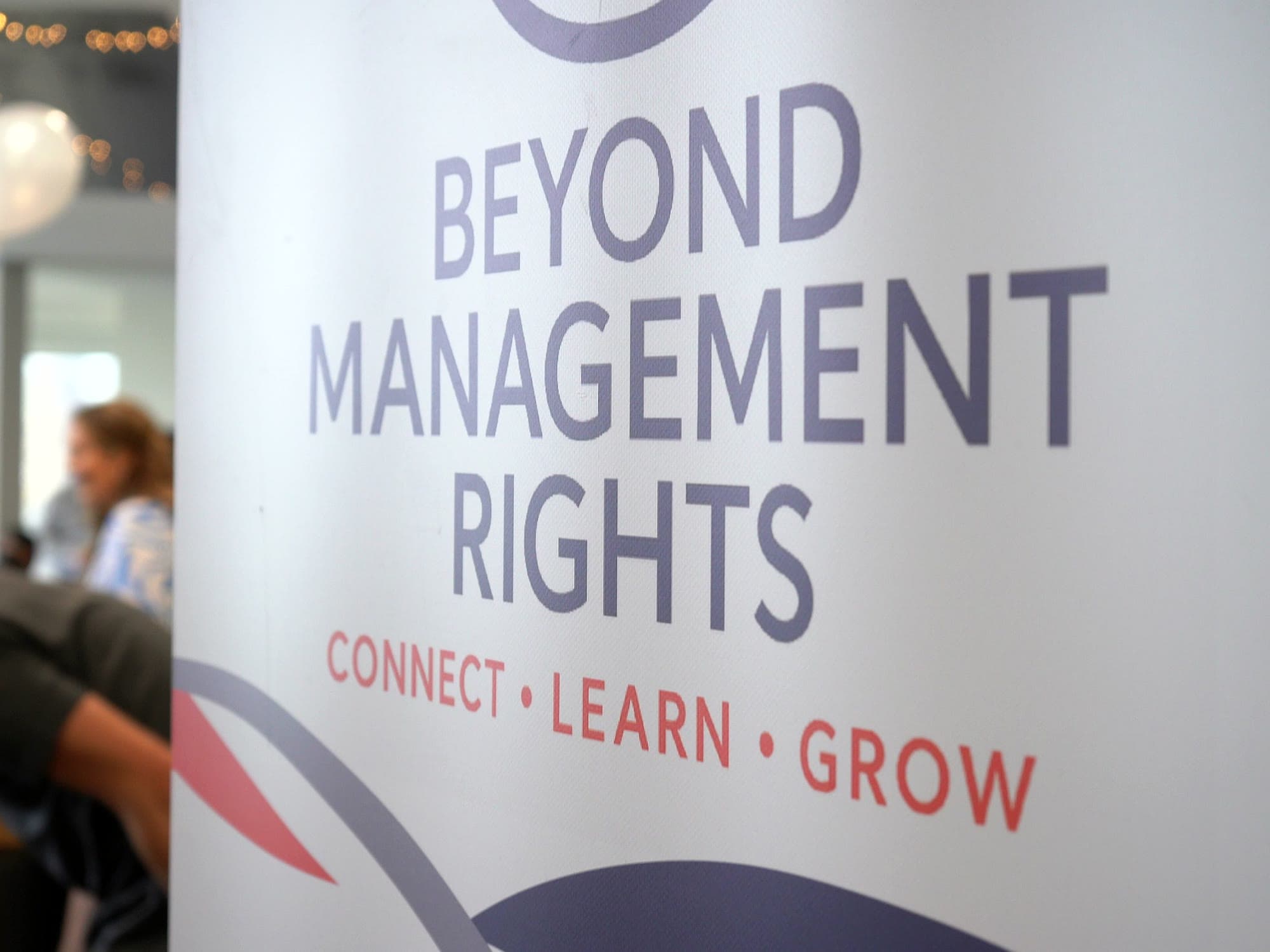 The Beyond Management Rights banner, reading Connect, Learn, Grow, in the function room.