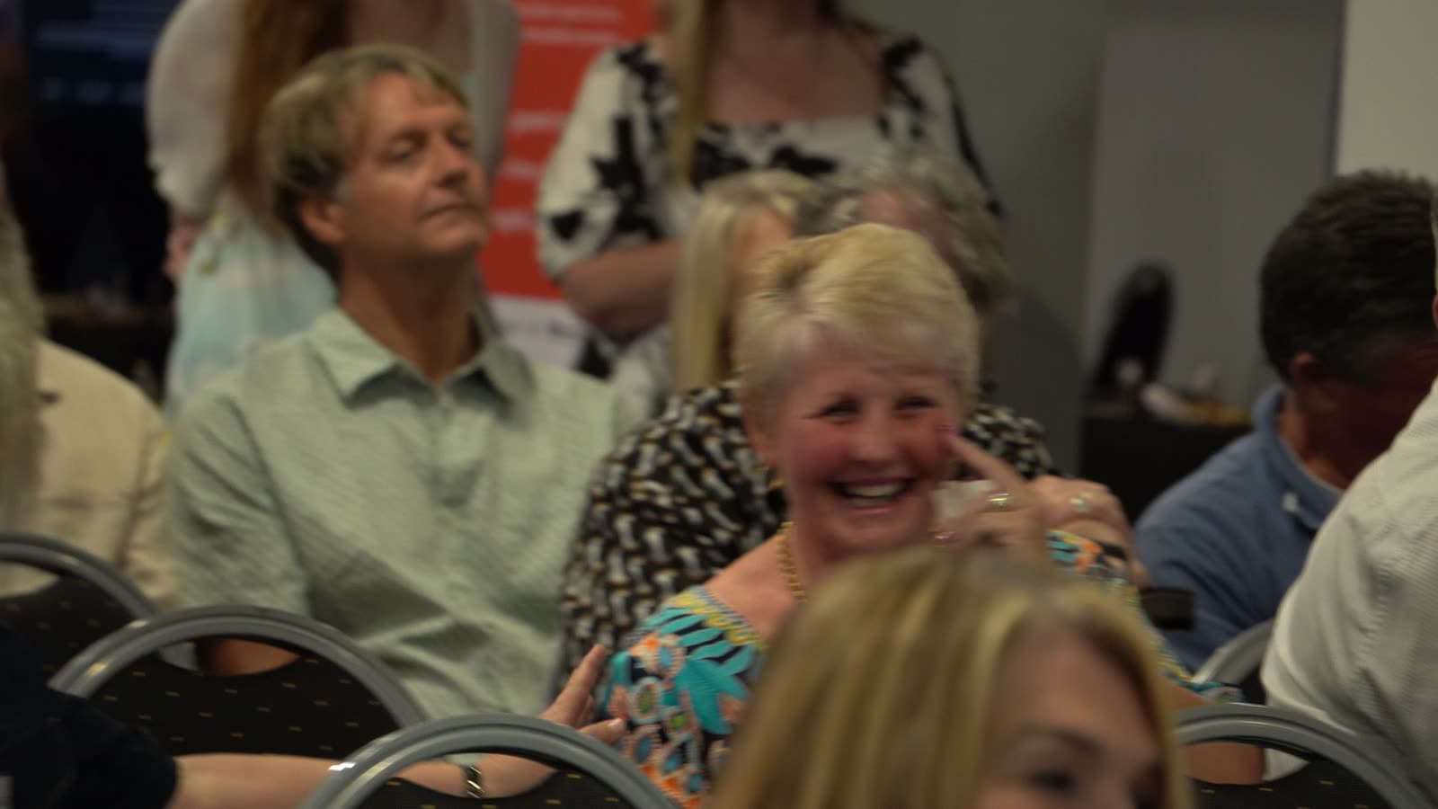 Guests laughing together in the audience during the evening programme.
